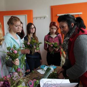 Floristin Ines Wagner übt mit den Schülern das Binden von Blumensträußen.